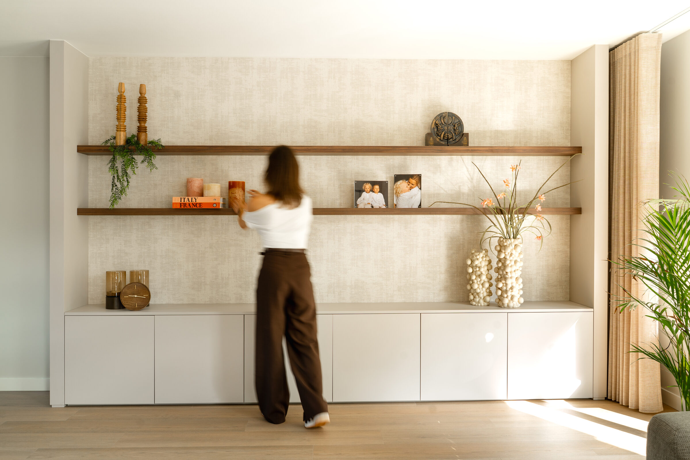 Warm, licht interieur met houten wandplanken en styling